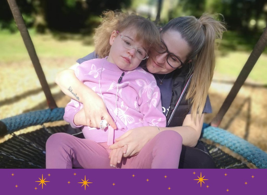 Phoebe and her mum hugging on a swing at Drayton Manor.